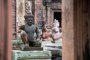 The demon statue guardian of the ancient ruins Banteay Srei the beautiful pink sandstone temple in...