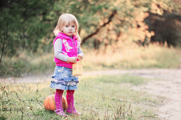 little girl with pumpkin outdoor