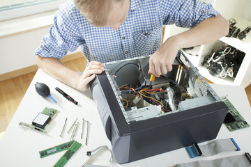 Young man fixing computer