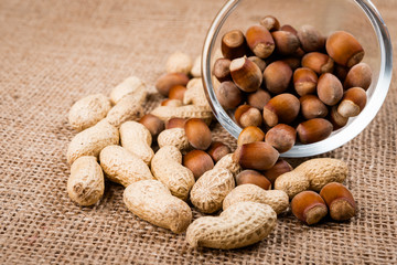 close up of nuts on glass bowl and burlap