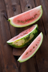 Fototapeta na wymiar Watermelon slices on a rustic wooden surface, high angle view