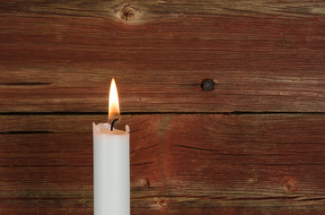 Fototapeta na wymiar Single candlelight at old wall