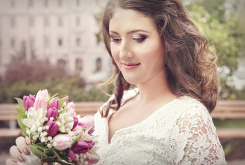 Fototapeta premium Beautiful bride smiling, holding wedding bouquet