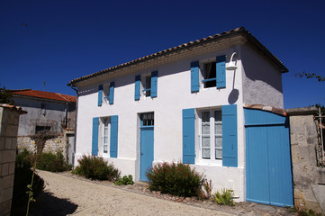 Fototapeta na wymiar Maison blanche à volet bleu de Talmont-sur-Gironde