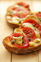 Bruschetta with tomatoes, brie cheese and capers
