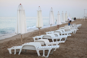 sandy beach sunbeds umbrellas sea