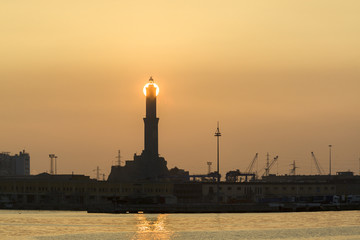 Sole al tramonto dietro la lanterna di Genova