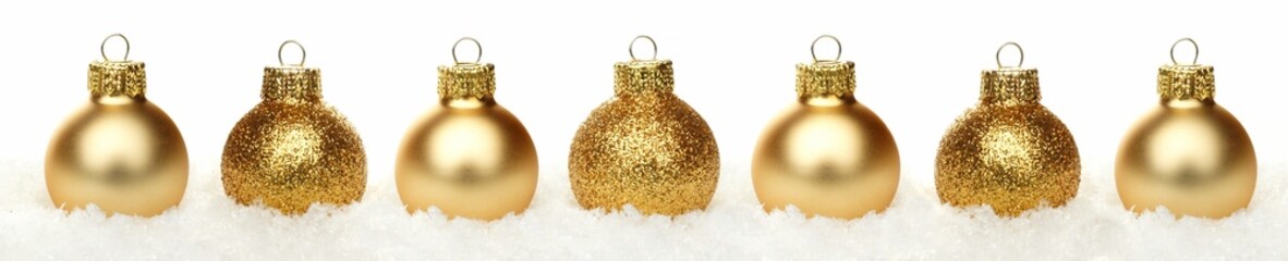 Christmas border of shiny gold baubles resting in snow