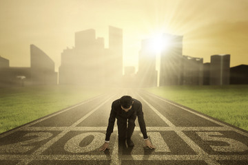 Businessman kneeling on track