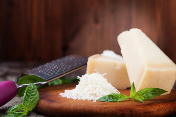 grated parmesan cheese and metal grater on wooden board © Gresei