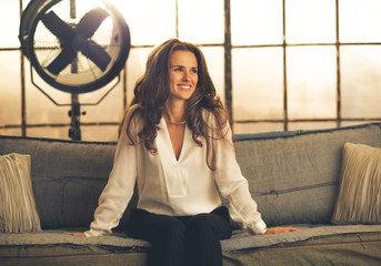 Portrait of smiling elegant young woman in loft apartment