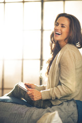 Portrait of smiling woman using tablet pc in loft apartment