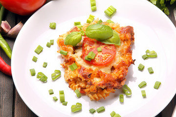 Portion of casserole with tomato and mushrooms on a plate
