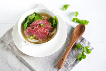Beef soup from Vietnam, pho, raw meat  with coriander and chili