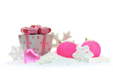 Gift box and pink Christmas ornaments on snow