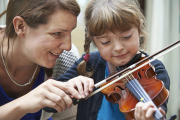 Teacher Helping Young Female Pupil In Violin Lesson © highwaystarz