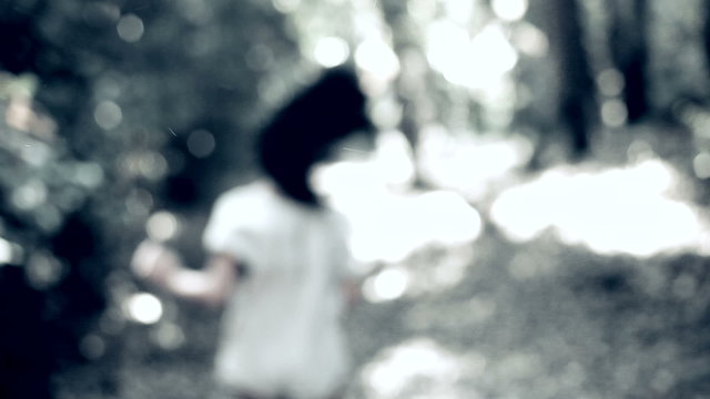 Woman running scared in forest horror sequence