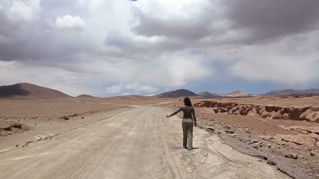 Woman catches the car at deserted road, Bolivia