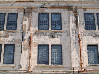 Fototapeta na wymiar prison facilities rusted windows on exterior wall