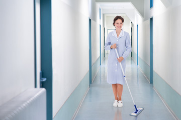 Happy Cleaner Mopping Floor In Hospital