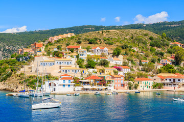 Fototapeta na wymiar Colorful houses of Assos port and boats on sea, Kefalonia island