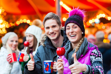 Freunde, Glühwein und Kandisäpfel auf Weihnachtsmarkt