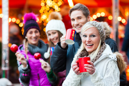 Freunde, Glühwein und Kandisäpfel auf Weihnachtsmarkt