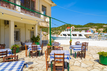 Fototapeta premium Krzesła i stoły w greckiej restauracji, port Vathi, wyspa Itaka