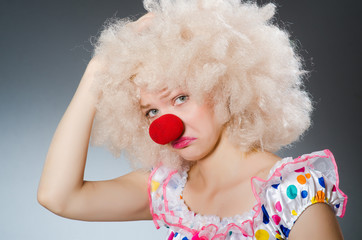 Clown with white wig against grey background