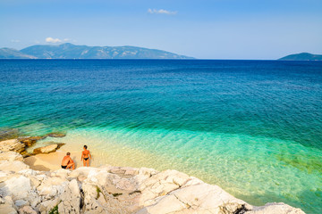 Fototapeta na wymiar Couple of people relaxing on beach, Kefalonia island, Greece
