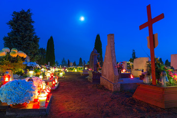 Cemetary at night with colorful candles in All Saints Day