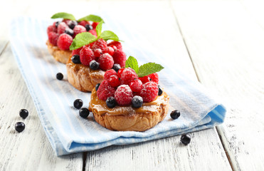 Sweet cakes with berries on table close-up