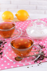 Cups of tea on table on brick wall background