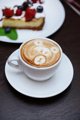 Cup of coffee with cute drawing in cafe