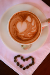 Cup of coffee with cute drawing in cafe