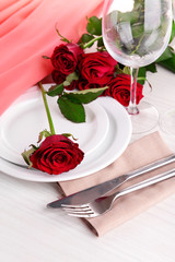 Table setting with red rose on plate