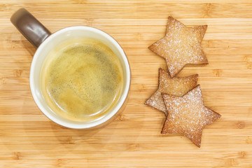 Christmas cookies in the shape of stars and a mug of coffee