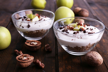 Oatmeal with yogurt in bowls, apples and walnuts