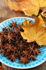 Stars anise on plate on wooden background