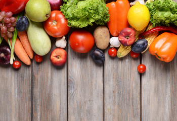 Fresh organic fruits and vegetables on wooden background