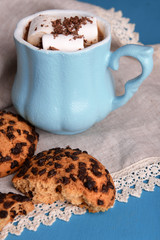 Cups of coffee with marshmallow and cookies on wooden table