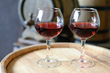 Glasses of wine in cellar with old barrels