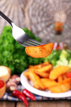Homemade fried potato on plate on wooden background