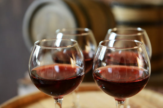 Glasses of wine in cellar with old barrels