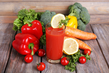 Tomato juice in glass and fresh vegetables