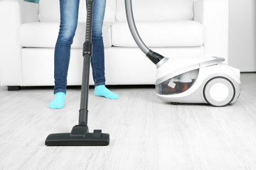Woman with vacuum cleaner in room