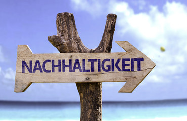 Sustainability (In German) wooden sign with a beach
