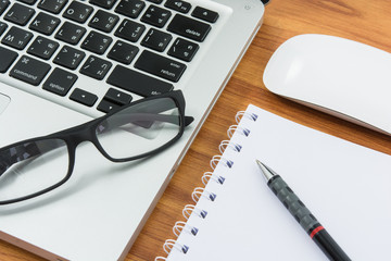 Blank business laptop, mouse, pen, note and glasses