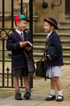 Brother and sister laughing at school gates