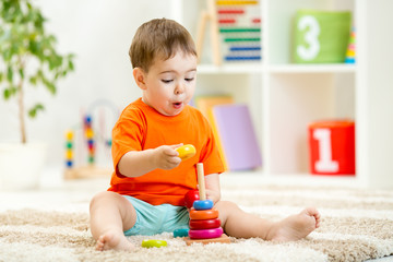 Child boy playing with toy at home